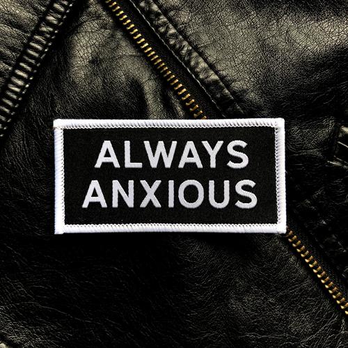 &quot;Always Anxious&quot; in white block text embroidered on black patch with white merrowed edge.  Art by Print Ritual.