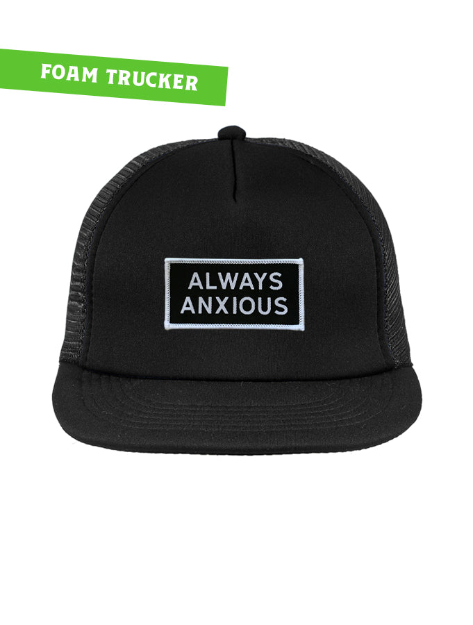 "Always Anxious" in white block text embroidered on black patch with white merrowed edge on a flat brim foam snap back.  Art by Print Ritual.