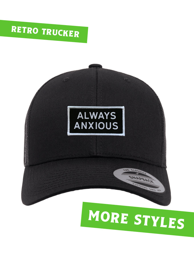 &quot;Always Anxious&quot; in white block text embroidered on black patch with white merrowed edge on a curved brim snap back.  Art by Print Ritual.