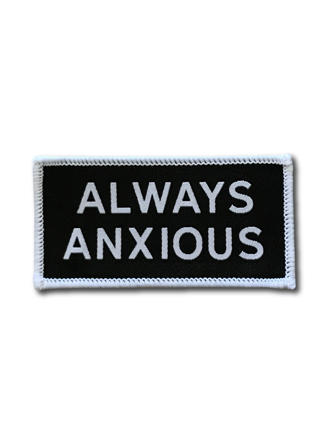 &quot;Always Anxious&quot; in white block text embroidered on black patch with white merrowed edge.  Art by Print Ritual.