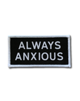 "Always Anxious" in white block text embroidered on black patch with white merrowed edge.  Art by Print Ritual.