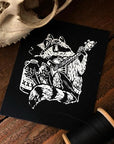 Racoon playing banjo next to jug in white ink on black rectangle sew on patch. Art by Collin Hammin.